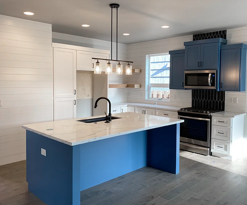 White Kitchen With Shiplap Walls And Dark Blue Cabinets 800x665