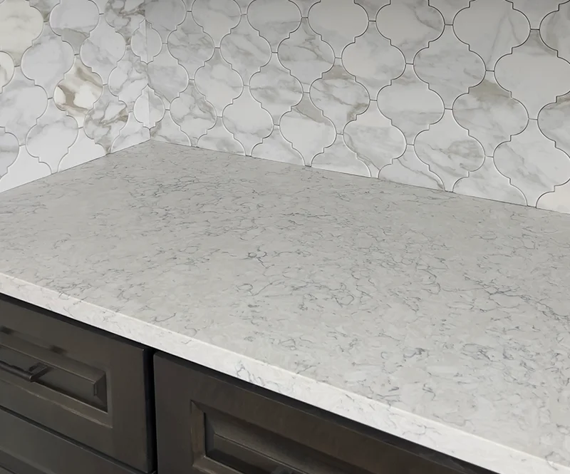 White Quartz Countertops With Marble Arabesque Tile Backsplash 800x665